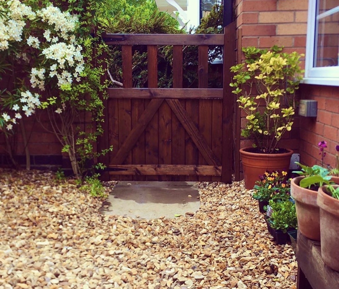 an image of a deep red, mahogany coloured gate outside a modern home