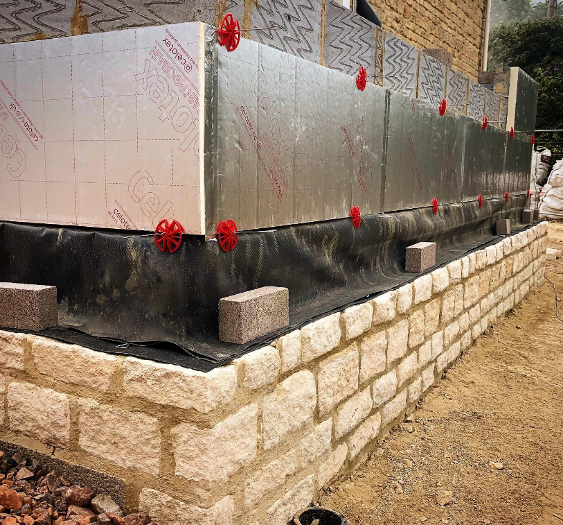 an image of a bricked house with Celotex insulation being installed