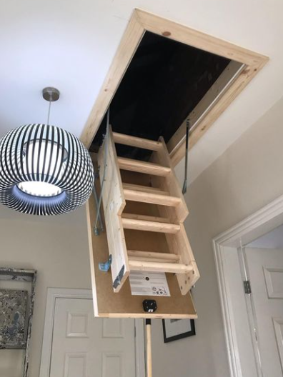 an image of a wooden loft ladder being used to reach the loft