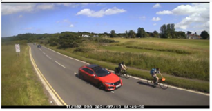 a car passes a person on a bike fairly closely on the road
