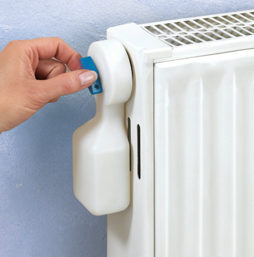 an image of a person inserting radiator bleed key into radiator