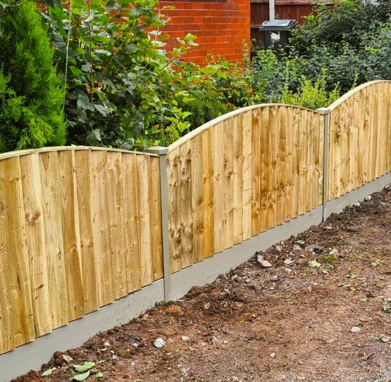 an image of a small wooden timber fence with small concrete posts and trim. 