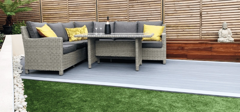 An image of some garden furniture placed on top of some composite decking in the summer outside to show a finalised deck after it has been installed and laid and cleaned.
