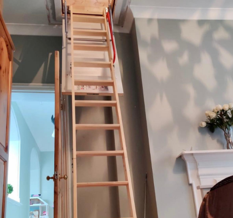 an image of a wooden stairs being used to reach the loft in a hallway