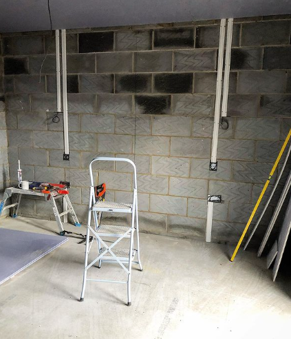 an image of a white ladder in grey stone garage 