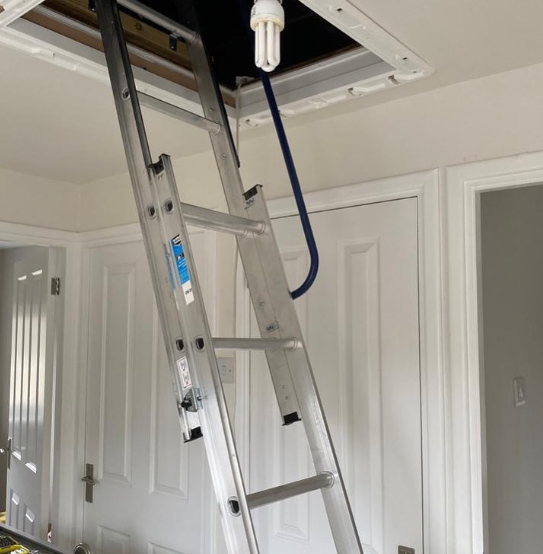 an image of a chrome ladder being used to reach the loft in hallway