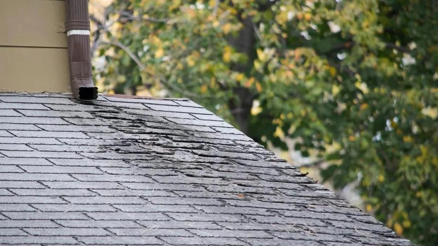 A damaged roof on the outside, showing a possible leak of the roof underneath in the attic.