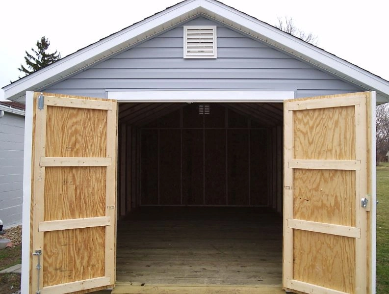 A baby light blue shed with timber doors open wide 