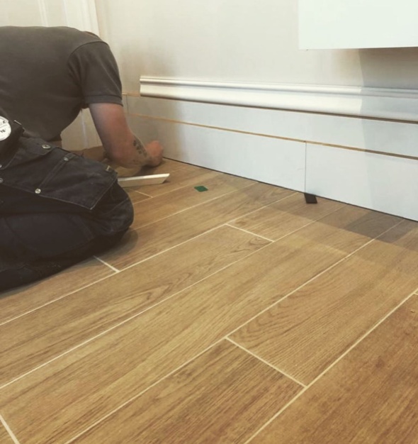an image of a man fitting skirting boards in home