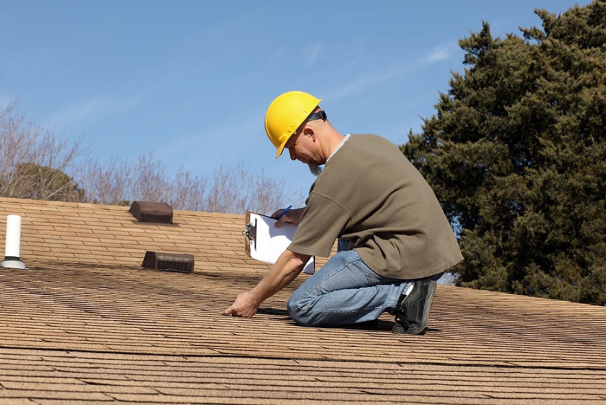 an image of a person with a yellow hard hat on top of a roof