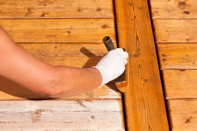 An image of a brush and sealent being used to reseal the decking once it has been cleaned.