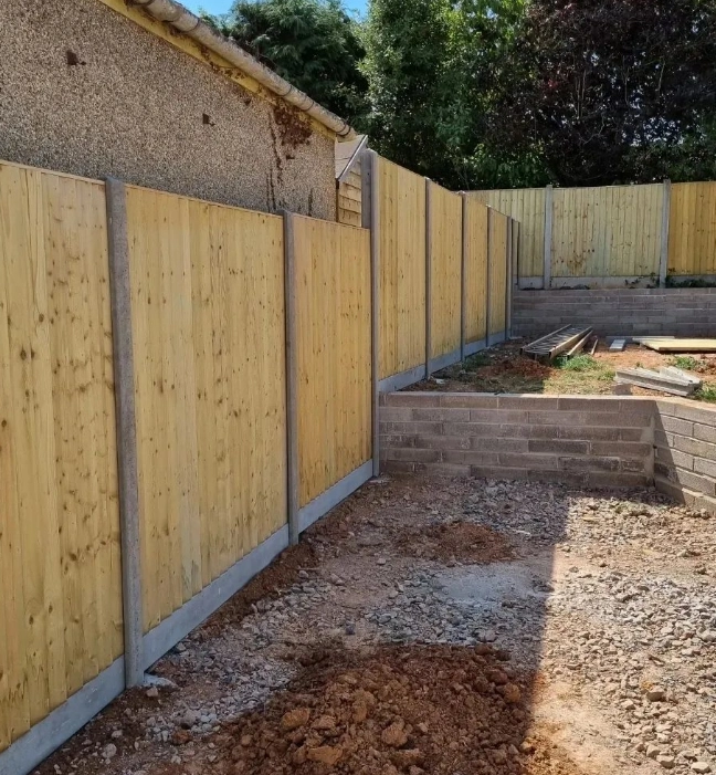 an image of a wooden fence panel in construction, with concrete timber posts. 