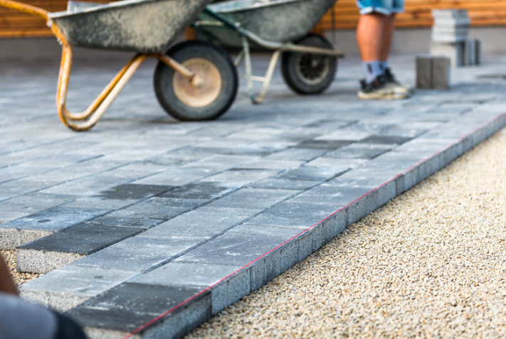 an image of block paving being laid and wheelbarrows 