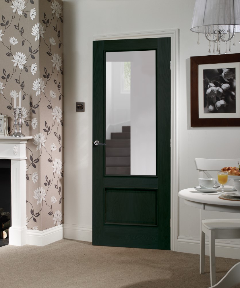 An image showing Andria Internal Americano Black Oak Door with Clear Bevelled Glass and Raised Mouldings  in a kitchen. flower wallpaper on the left of the image and kitchen table on the right