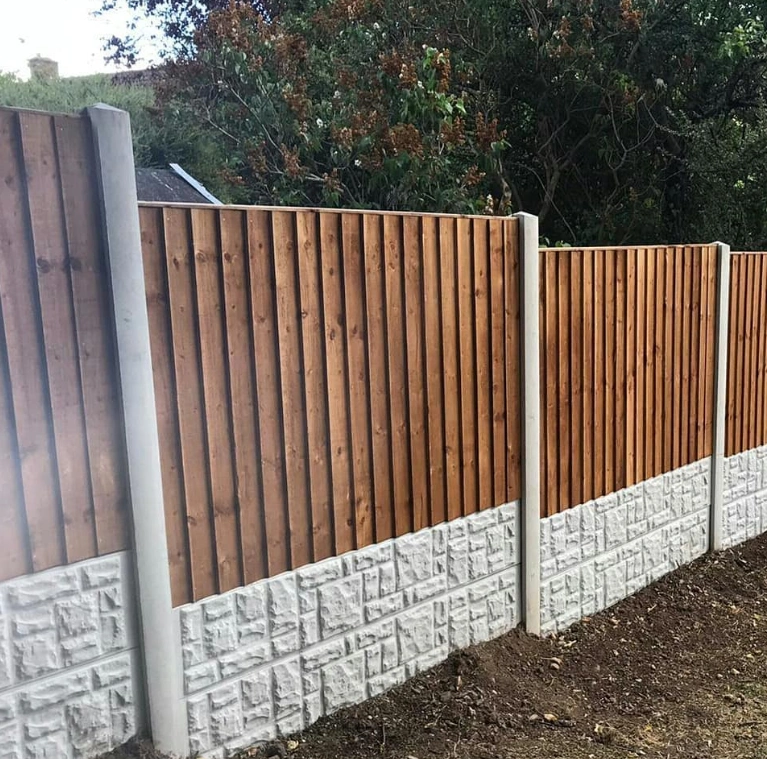 an image of a mahogany brown fence with white posts and a white brick trim.