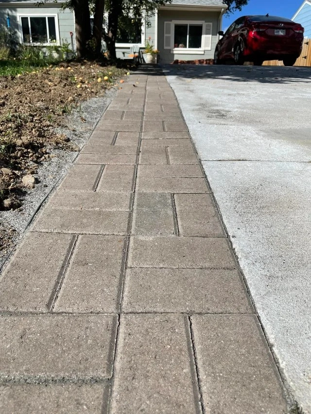 A driveway with pavers and edging, combining durability and elegance for a polished, structured appearance.