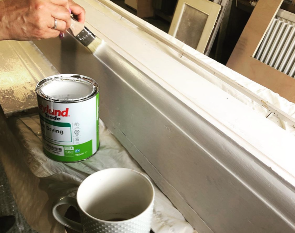 an image of a man painting skirting board white