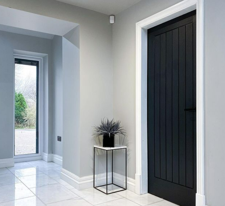 an image of a slate black door in a bright hallway with table
