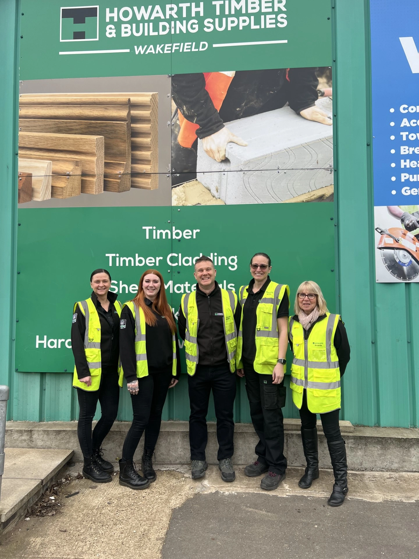Four people pictured in front of the Howarth Timber logo sign, one of which being Ashley Rice, our new Assistant Branch Manager