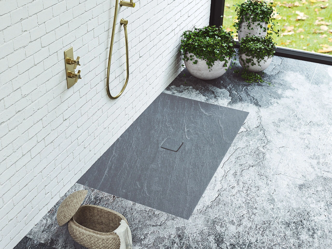 An anti-slip shower tray used in an outdoor shower with plants and shrubby surrounding it. 