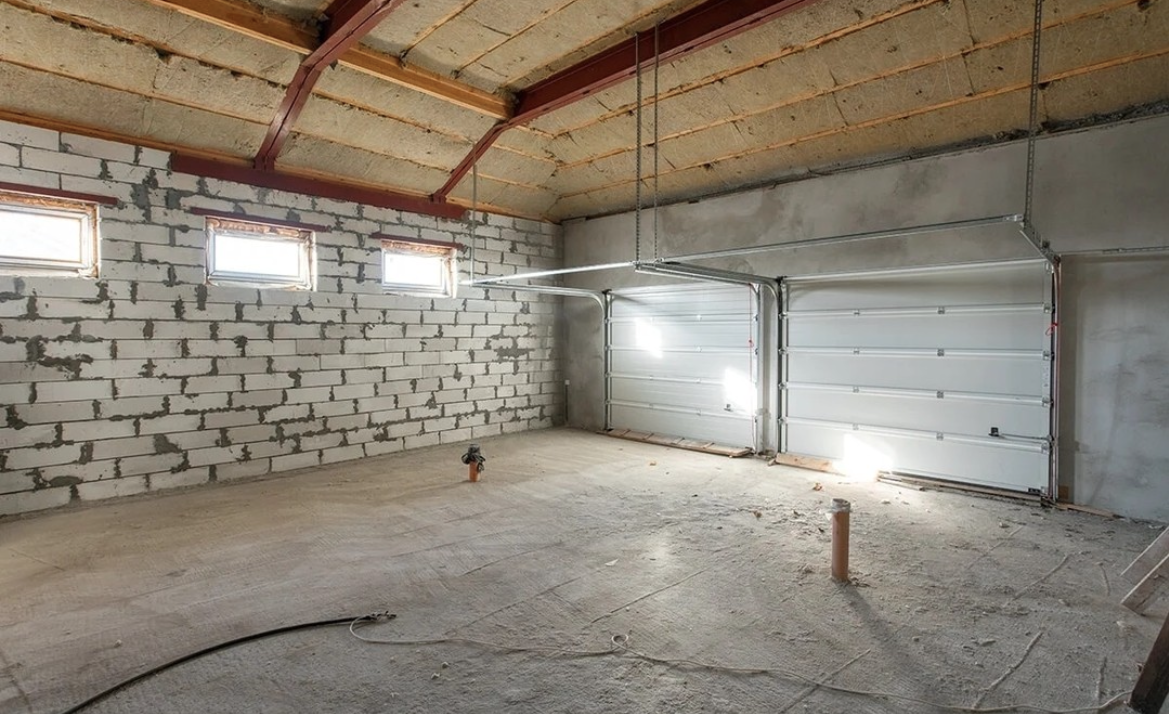 An image showing inside a double garage with insulated ceiling and exposed brick.