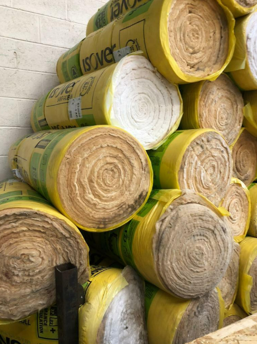 isover wool insulation rolls stacked against wall