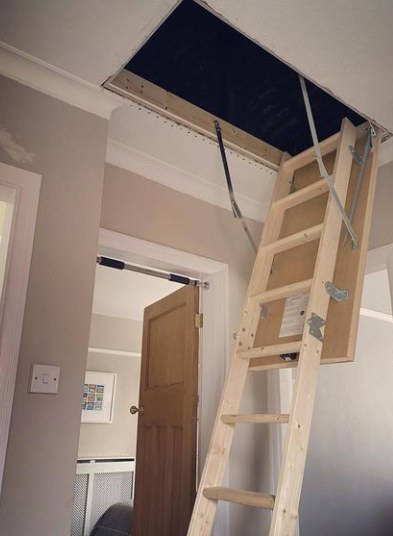 an image of a wooden stairs being used to reach loft in hallway