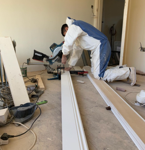 an image of a man drilling hole into skirting board