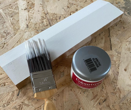 an image of a bright white skirting board with paint besides it