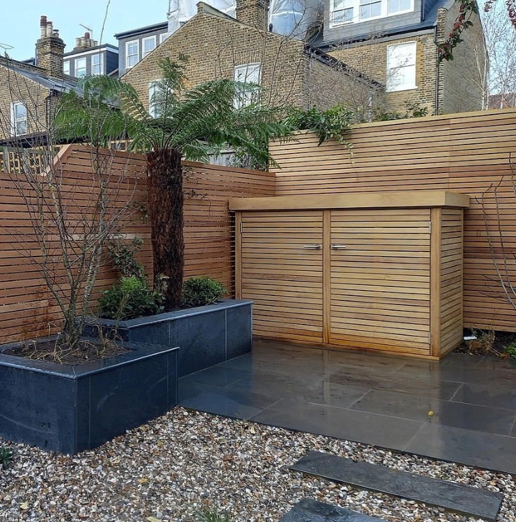 an image of a modern timber fence amongst a garden shed and aggregate garden. 