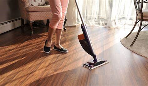 an image of a woman using vacuum to clean laminate floor