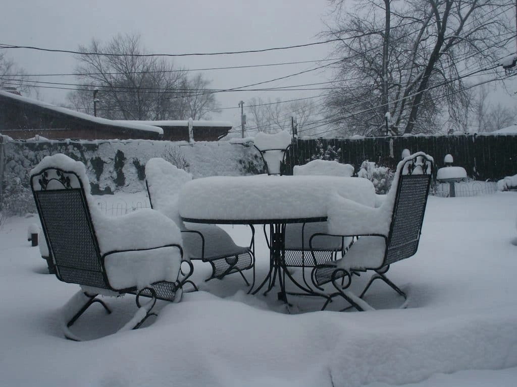 Garden furniture outside covered in a thick blanket of snow.