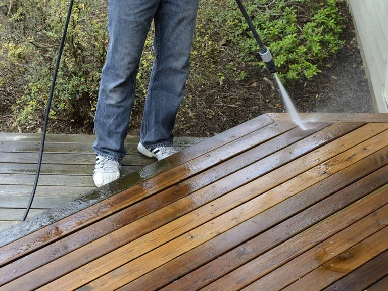 A jet wash being used with on decking to clean and maintain it.
