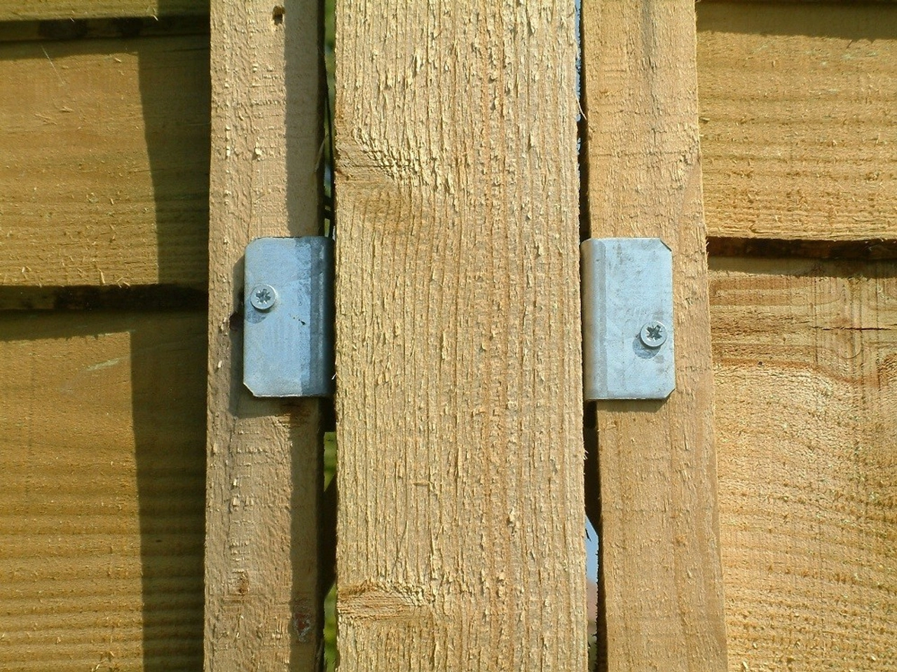 an image of fence panel clips inserted into a beige coloured fence. 