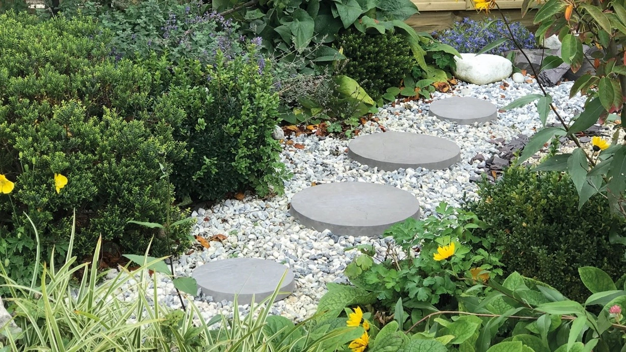 Tranquil garden oasis featuring beautifully arranged stepping stones, inviting a serene journey through nature's embrace. 