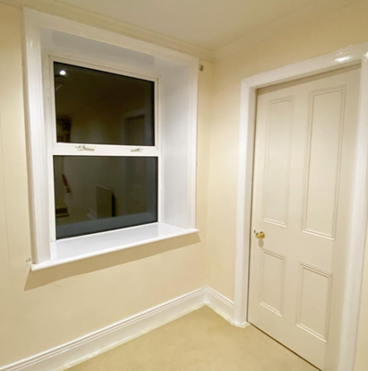 an image of a white painted room with white door and white window