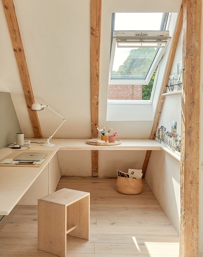 An office/study area with a roof window being used to let in more light to the room. 