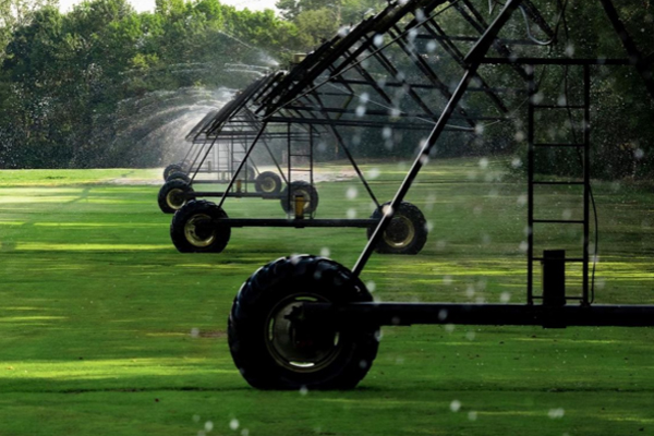 an image of some sprinklers watering some outside grass