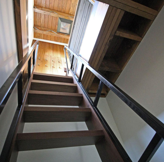 an image of a wooden stairs being used to reach the top of wooden loft