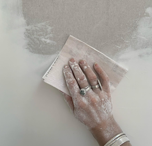 an image of a woman using sandpaper to scrape the wall