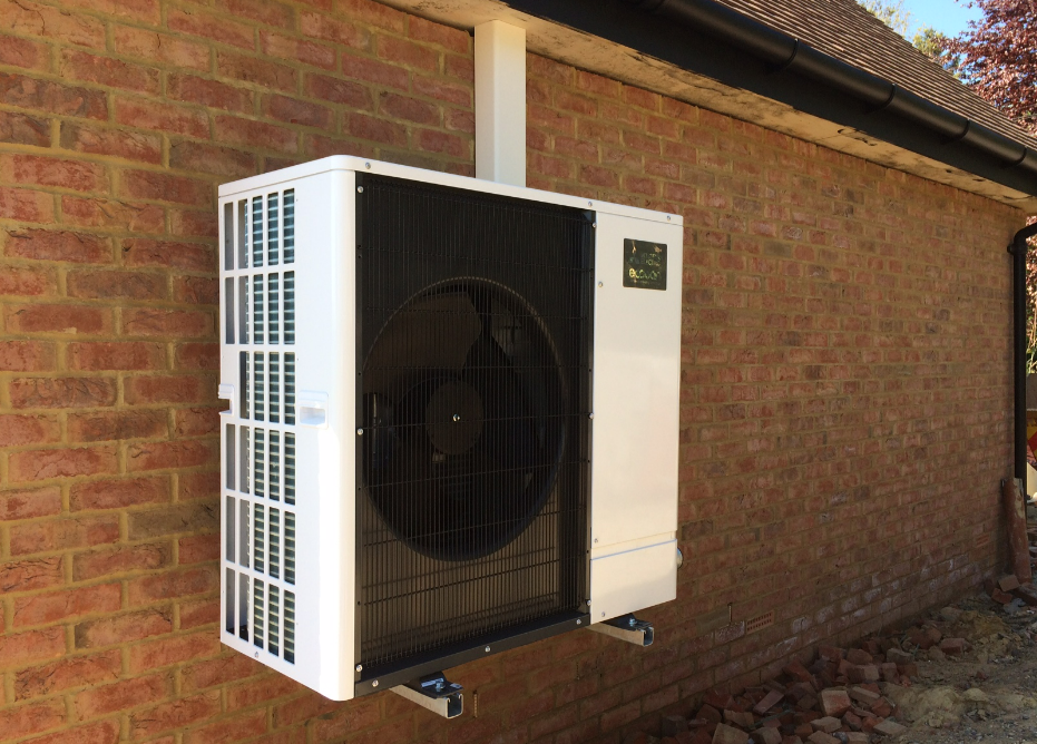 black and white air source heat pump against red brick house