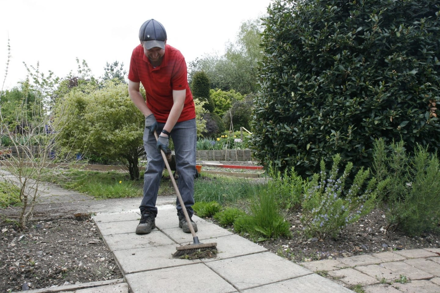 A person using a garden brush to brush down their patio to prepare for the winter months ahead.